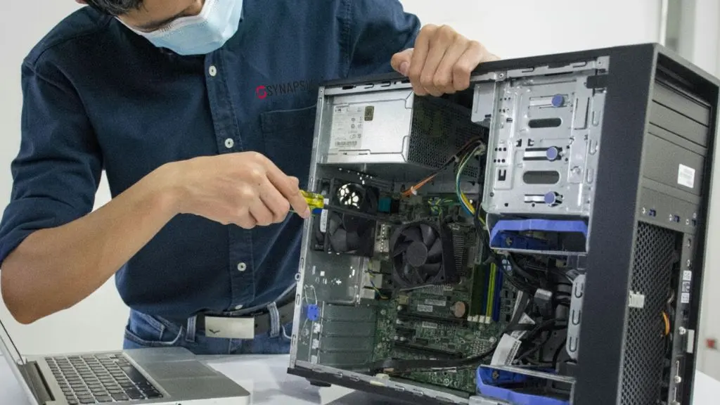 Técnico de Synapsia realizando mantenimiento preventivo y correctivo de equipos empresariales.