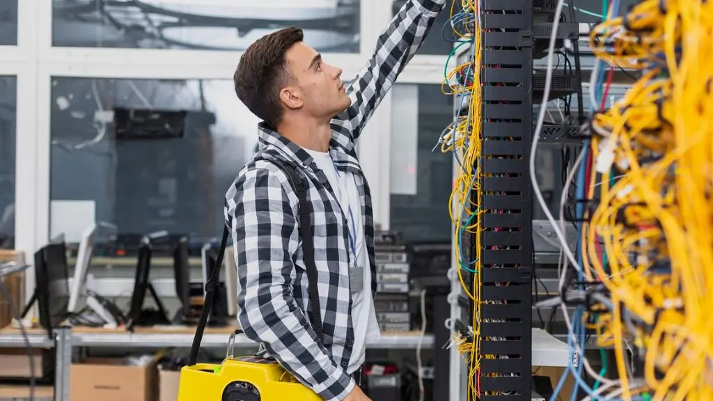 Técnico de Synapsia brindando soporte técnico en sitio a una empresa, revisando equipo de cómputo.